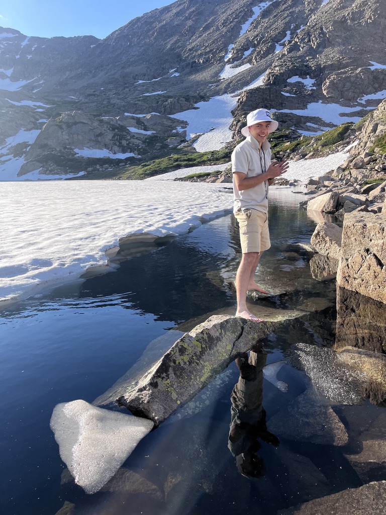 Samo standing barefoot by an alpine lake in the mountains.