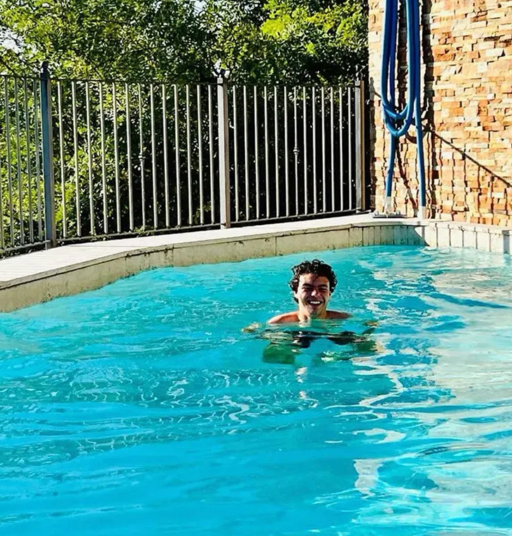 Samo smiling while swimming in a bright blue pool.